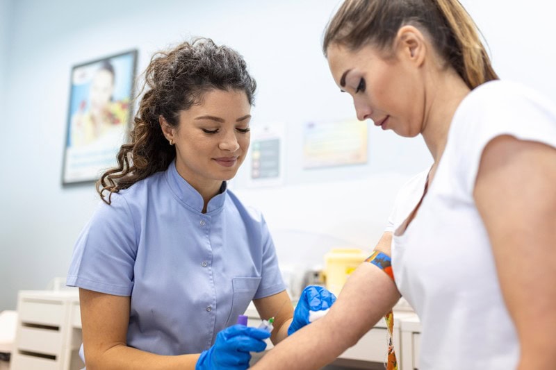 Infirmière effectuant une prise de sang sur une patiente dans un laboratoire médical