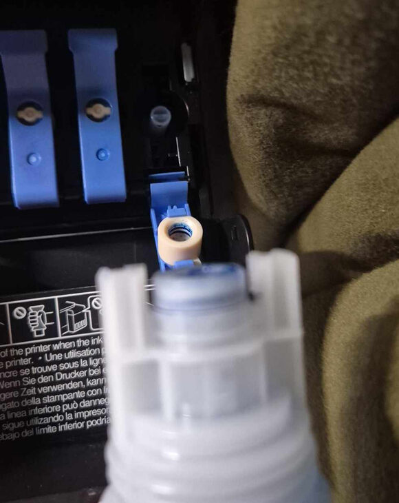 Flacon d’encre Epson 104 en cours de remplissage dans une imprimante EcoTank ET-2820
