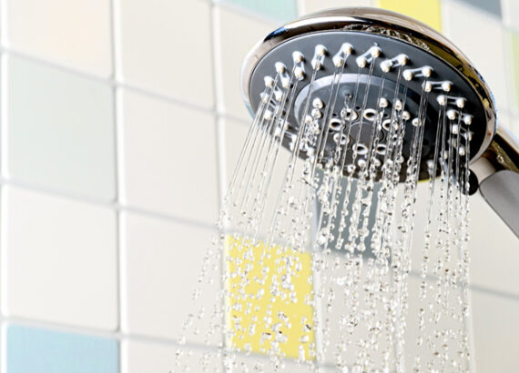 Pommeau de douche chromé avec jets d'eau sur carrelage coloré