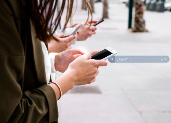 Personnes utilisant leurs smartphones avec une barre de recherche illustrant les tendances Google en 2023.